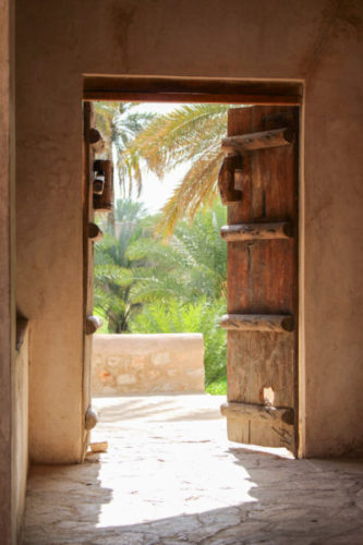 Looking-out-through-a-wooden-door-in-an-oasis-in-oman