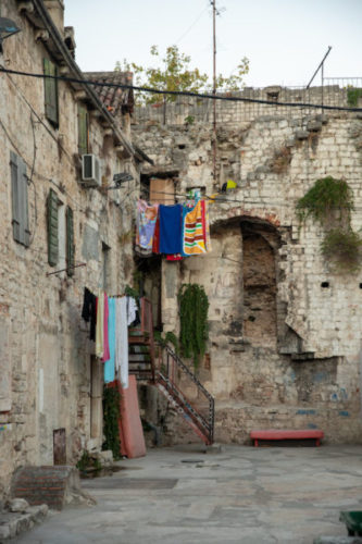 Laundry drying in front of ancient houses and crumbling walls
