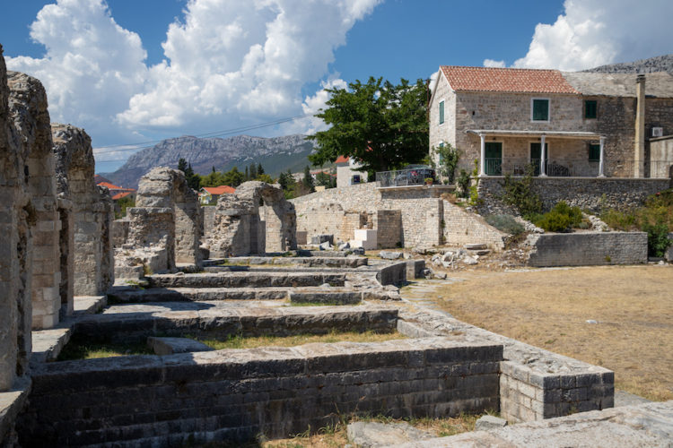 Roman ruins at salona next to a modern house