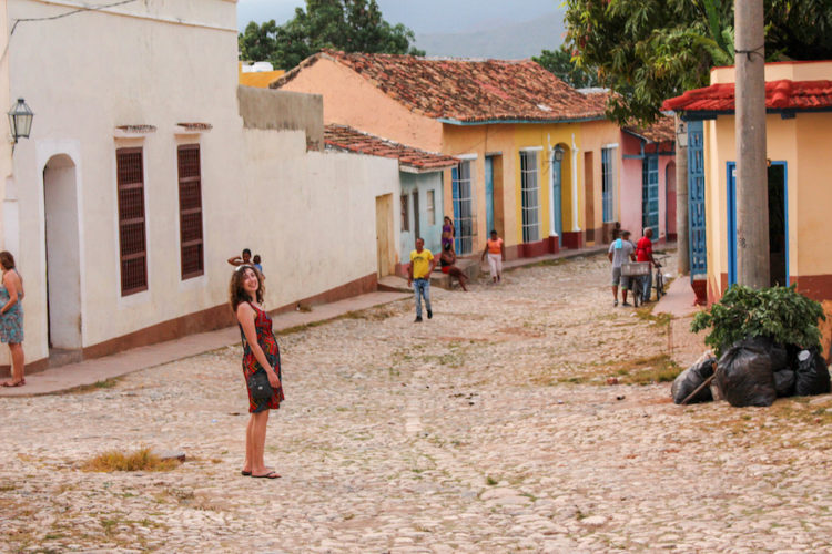 Exploring the cobbled streets of Trinidad, Cuba, with colourful colonial buildings and a few people walking by