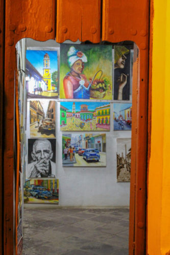 Oil paintings on canvasses displayed inside an artist's studio in Trinidad, Cuba
