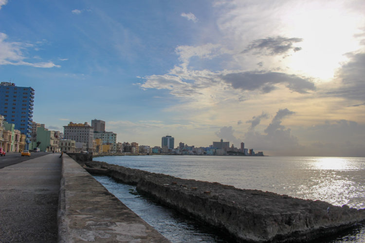 The malecon in Havana with the waterfront sidewalk, colourful buildings, and the sea