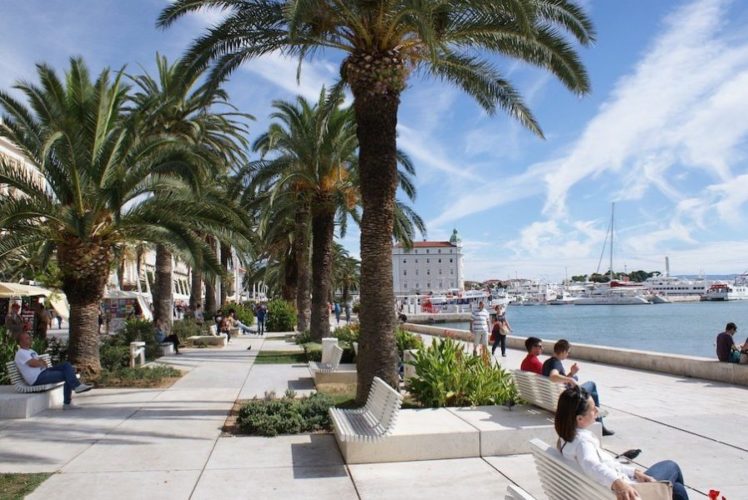 Riva-Promenade-on-a-sunny-day-with-people-sitting-on-benches