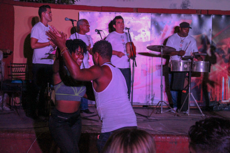 Man and a woman dancing in front of a live Cuban band playing in Trinidad