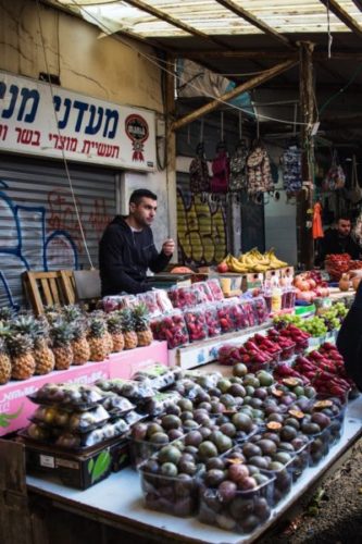 Man-selling-fruit-from-a-stand-in-Carmel-Market-Tel-Aviv