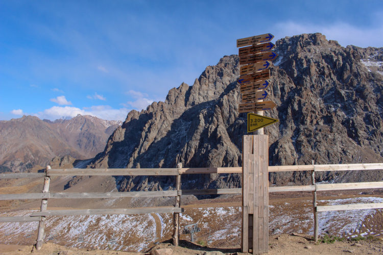 Signs-outsite-Bar-3200-in-shymbulak-with-jagged-rocky-mountains-behind