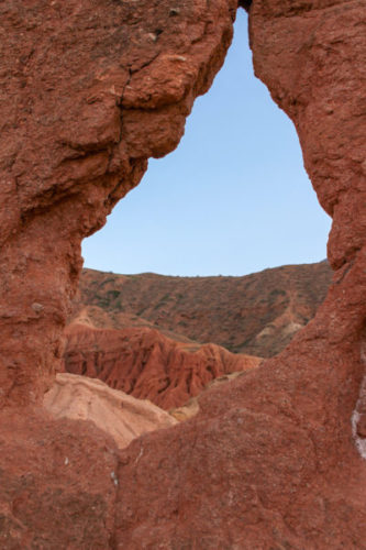 Natural rock arch window showing blue sky beyond in skazka canyon