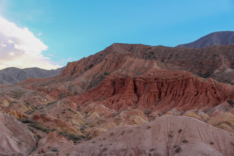Strange geological features at Skazka Canyon with pink, yellow, orange, and red rocks forming an otherworldly landscape 