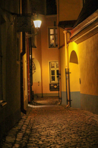 Tallinn's atmospheric backstreets at night illuminated by an old street lamp
