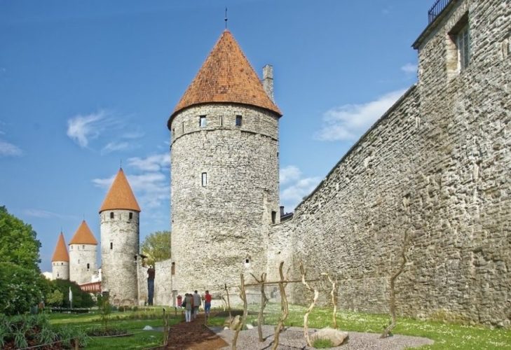 Tallinn's old city walls with four round stone towers with orange triangular tops