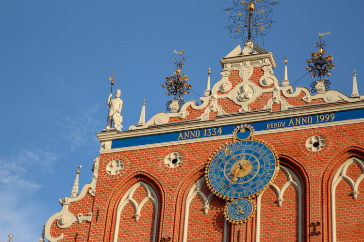 Close-up view of the clock on the house of the blackheads building in Riga with blue skies