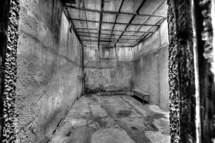 Black and white photo of the inside of a prison cell in the KGB building in Riga