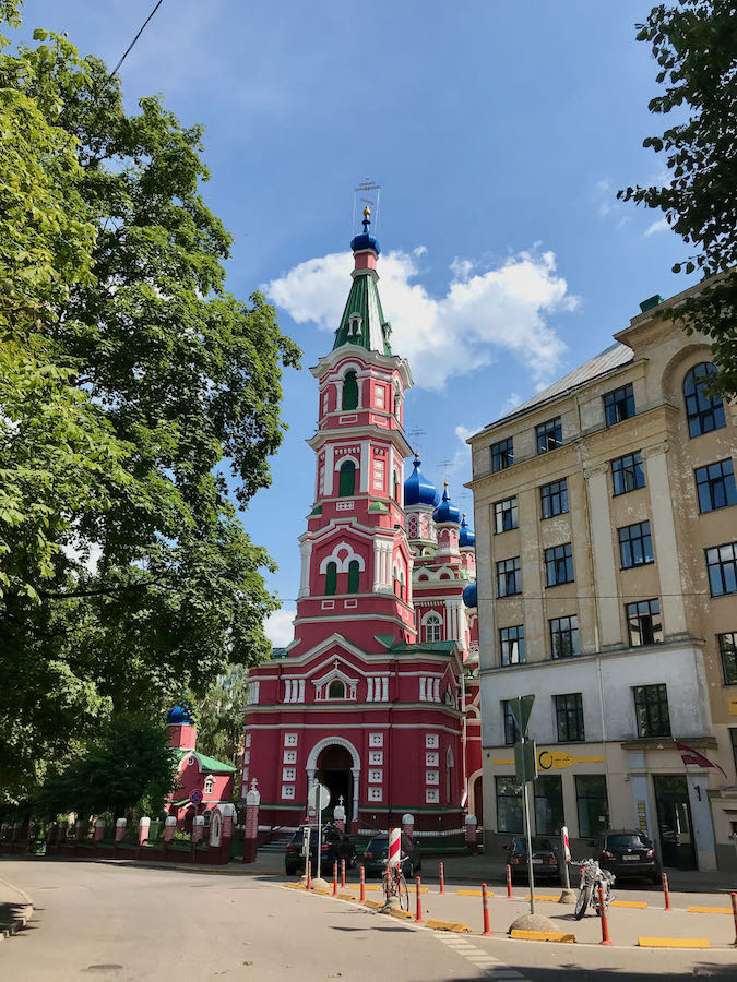 Colourful orthodox church in Riga with a red tower and blue domes