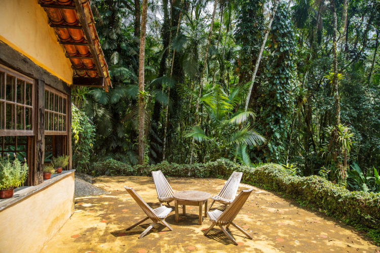 Pousada-Le-Gite-d'Indaiatiba-sun-terrace-with-table-and-chairs-and-jungle-beyond