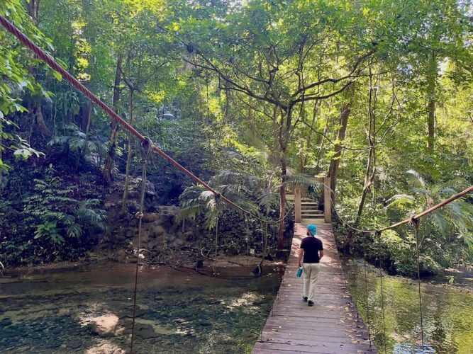 Alex-Tiffany-walking-over-a-small-suspension-bridge-in-palenque