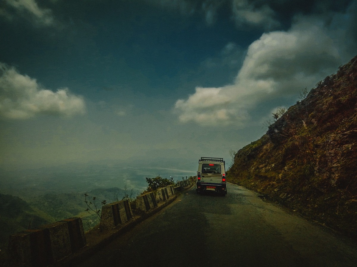 Old jeep driving along a Himalayan mountain road in West Bengal on the way to the hill stations