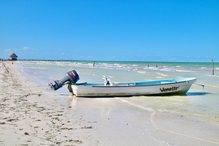 Little boat with an outboard motor on a beach in Isla Holbox