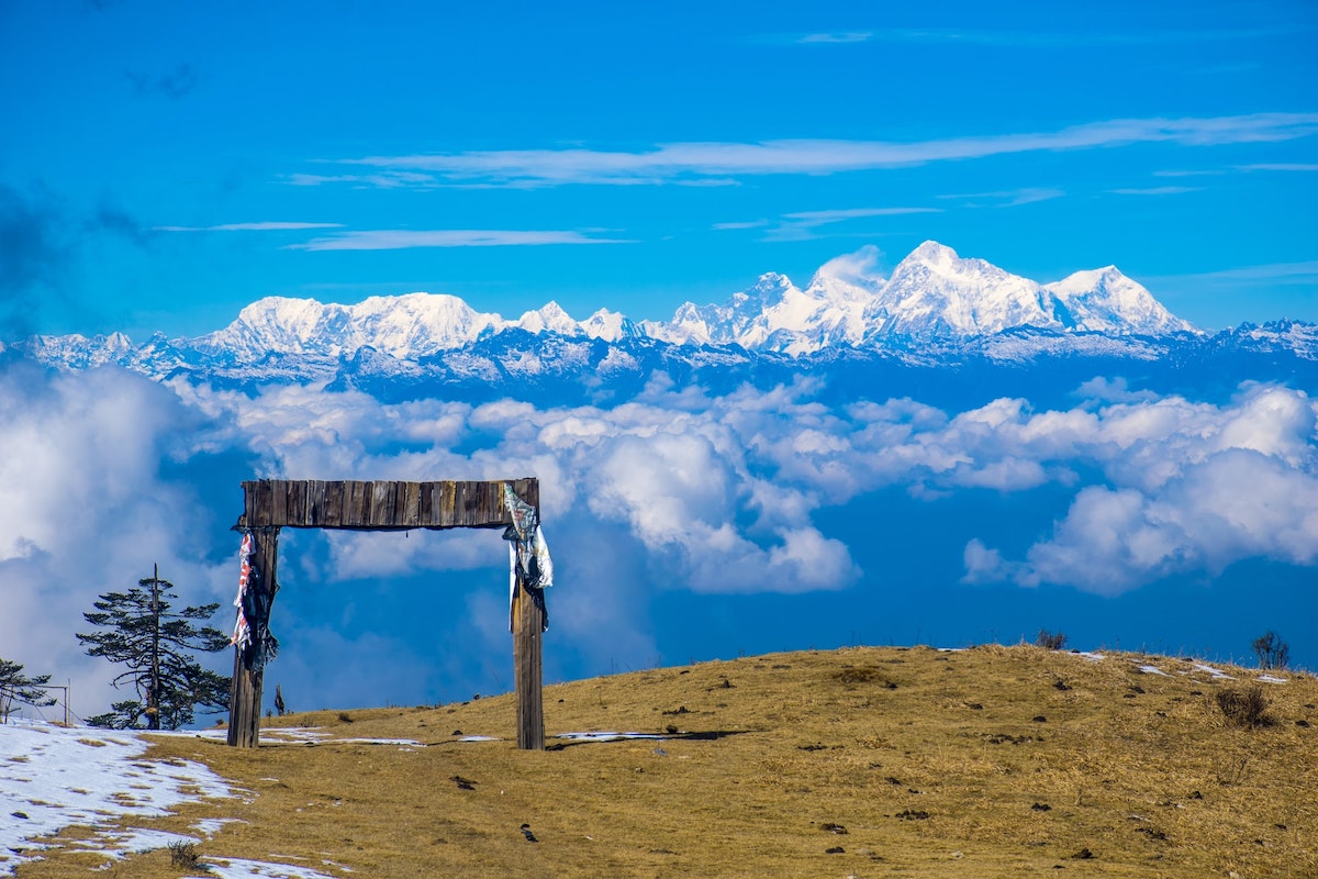 View from the edge of Sandakphu Hill Station with snow covered Himalayan peaks in the distance