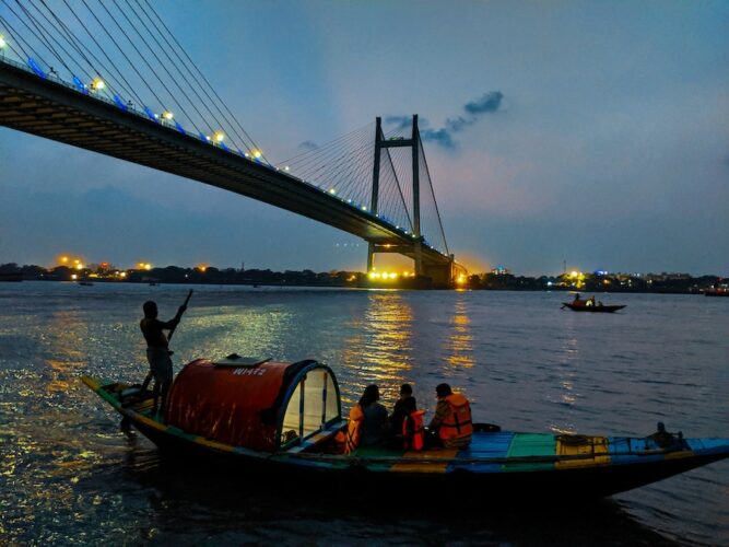 The-hooghly-river-and-howrah-bridge-at-night-with-a-small-boat-in-the-foreground