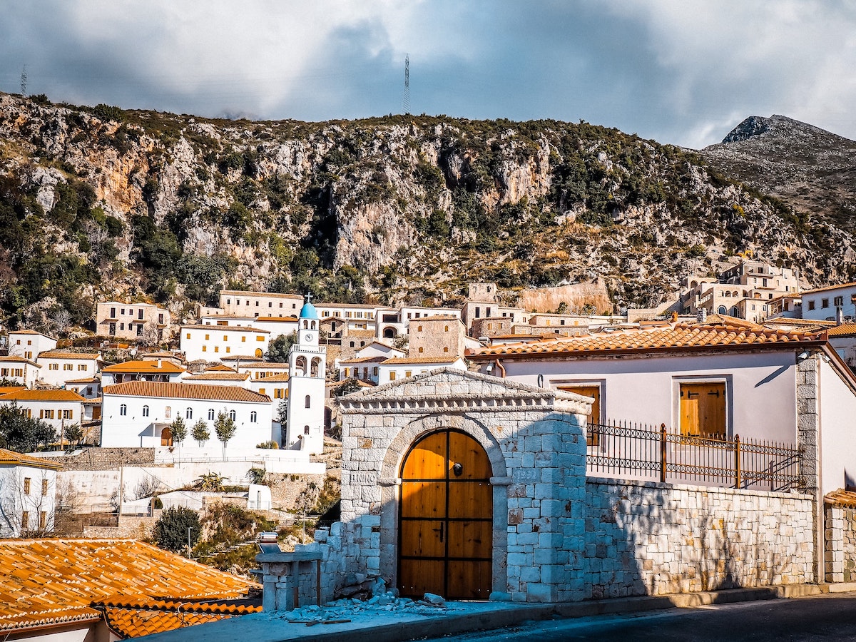 Attractive whitewashed buildings in Dhermi village with mountains behind
