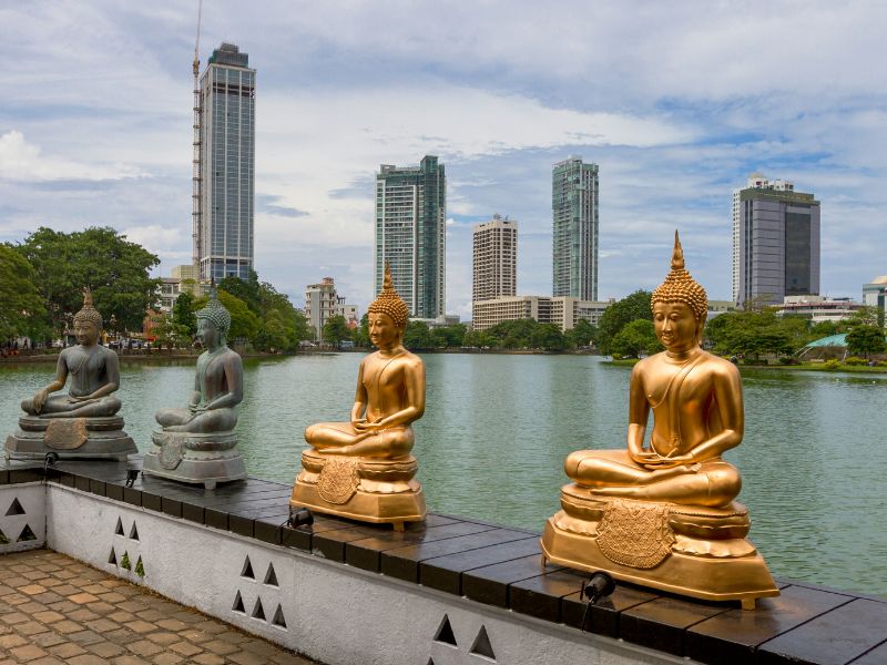 Beira Lake in Colombo with grey and gold buddha statues in the foreground