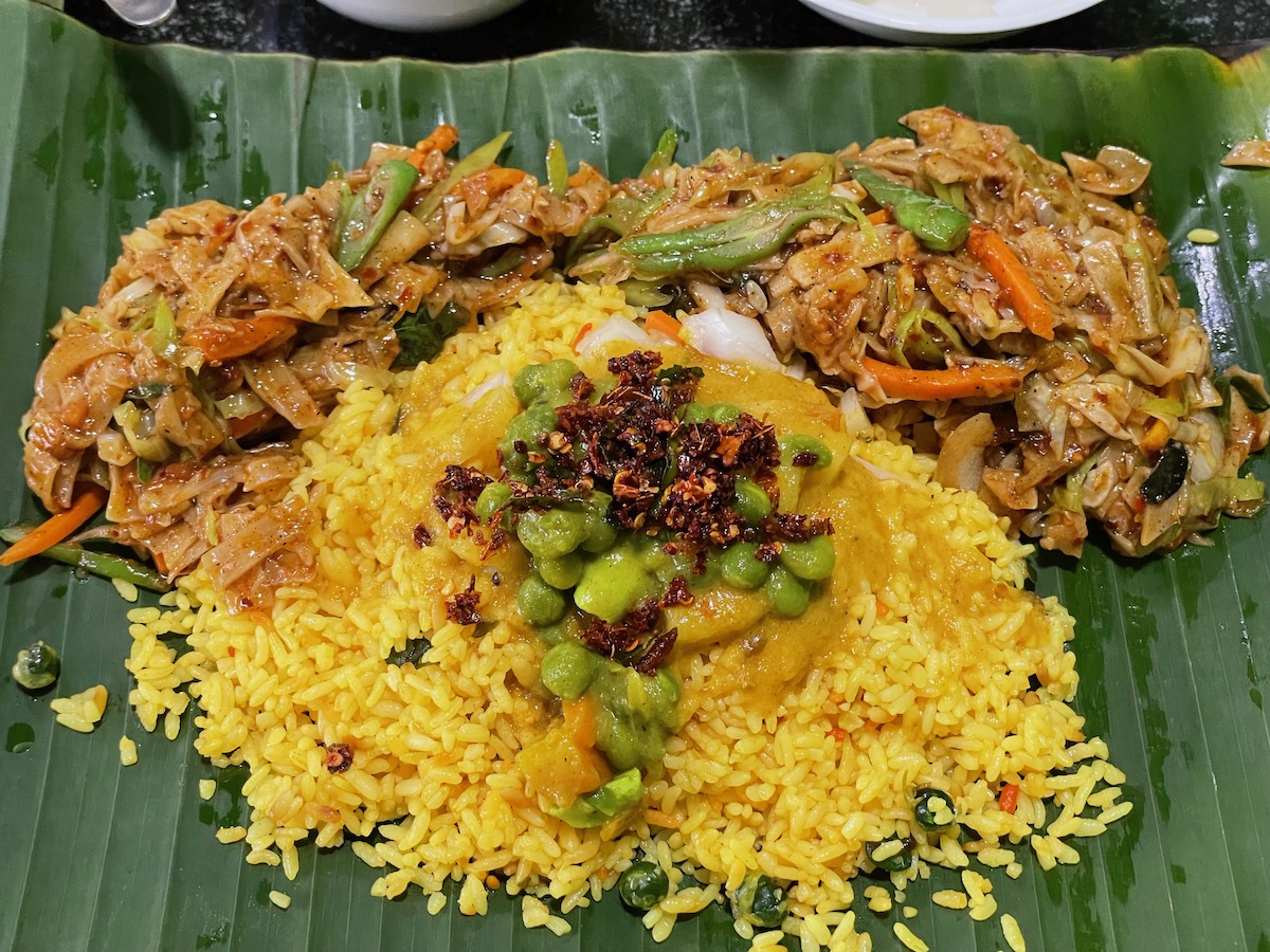 spicy rice and noodles with dahl and curry served on a banana leaf at a restaurant in colombo