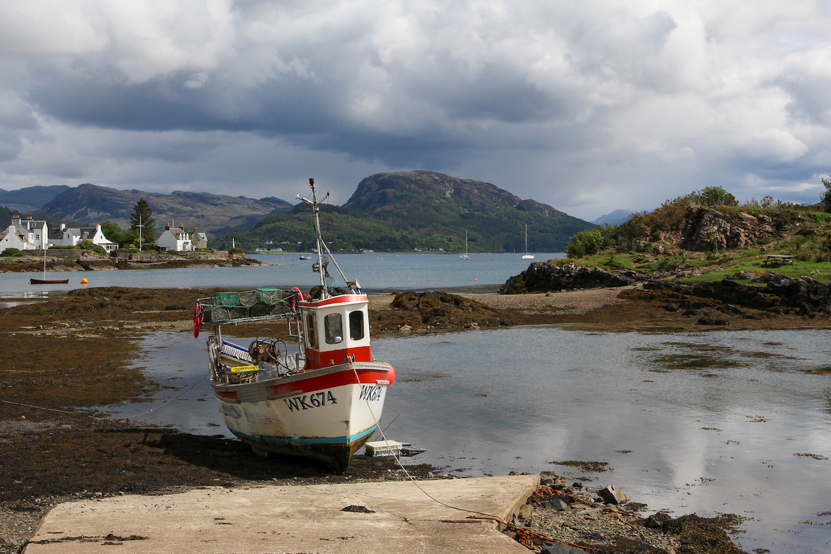 Plockton bay with a fishing boat and mountains beyond