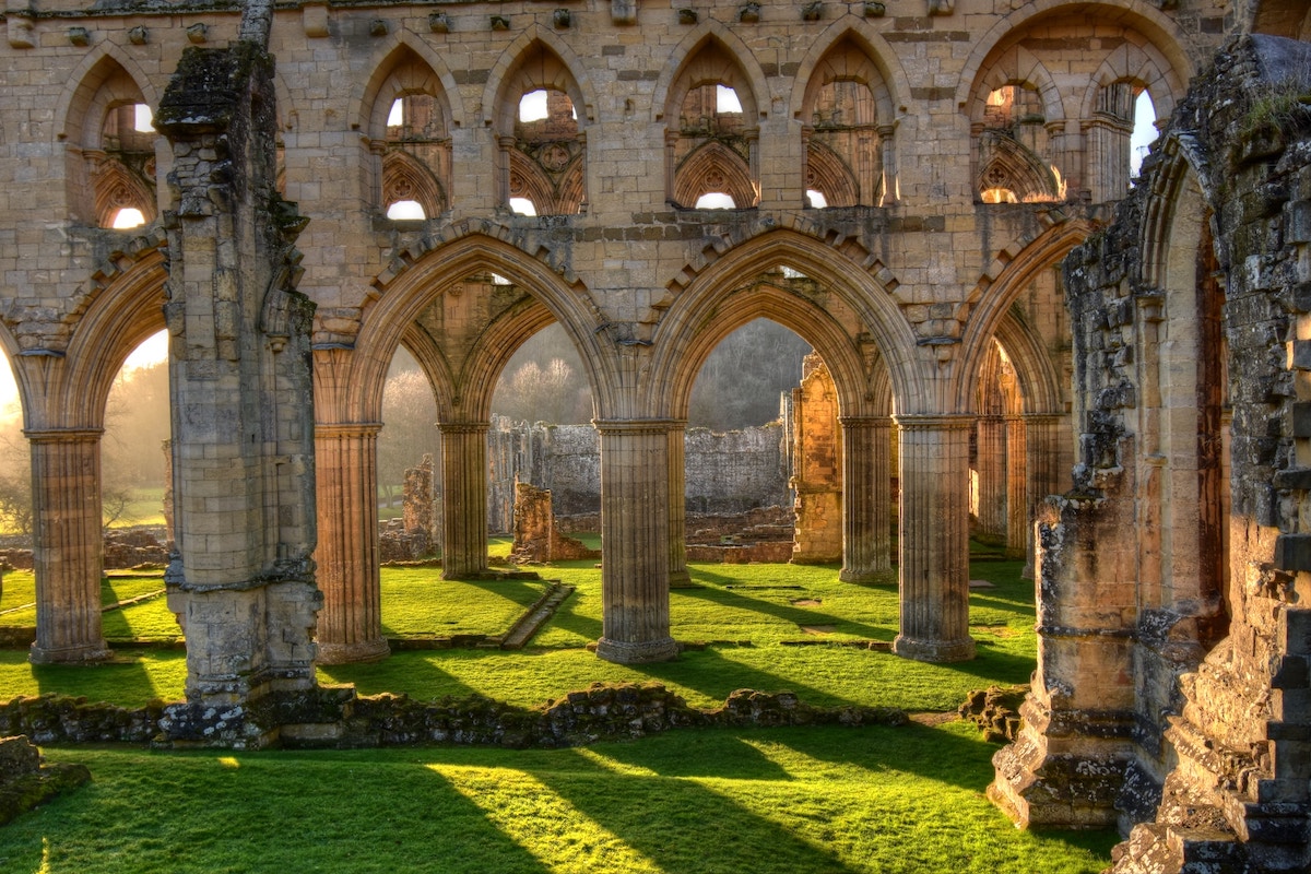 Ruins-of-Rievaulx-Abbey-stone-arches-with-green-grass-underneath