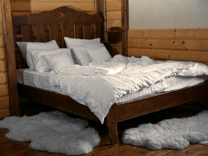 bed-with-white-linnen-inside-a-luxury-log-cabin