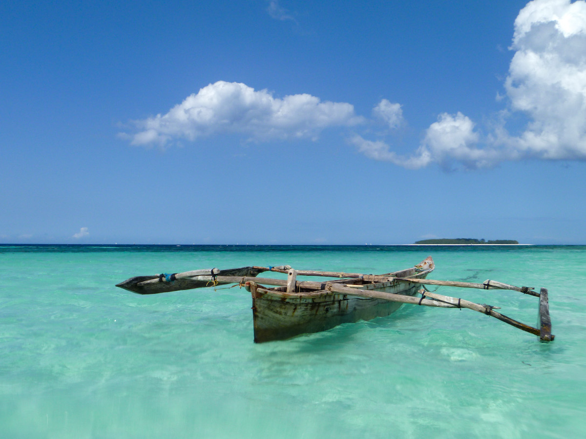 traditional-wooden-boat-with-outrigger-in-turquoise-water-in-zanzibar