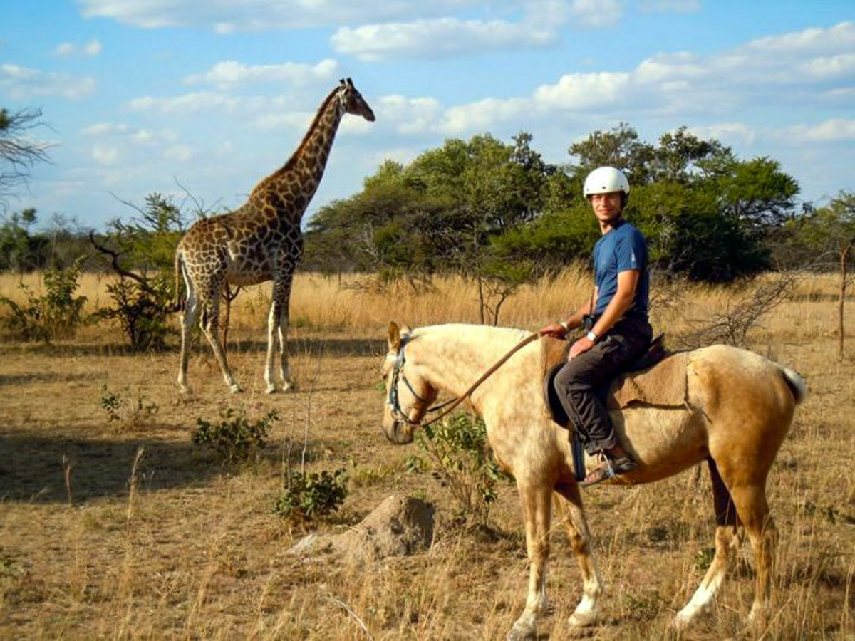 alex-tiffany-on-horseback-safari-tour-with-giraffe