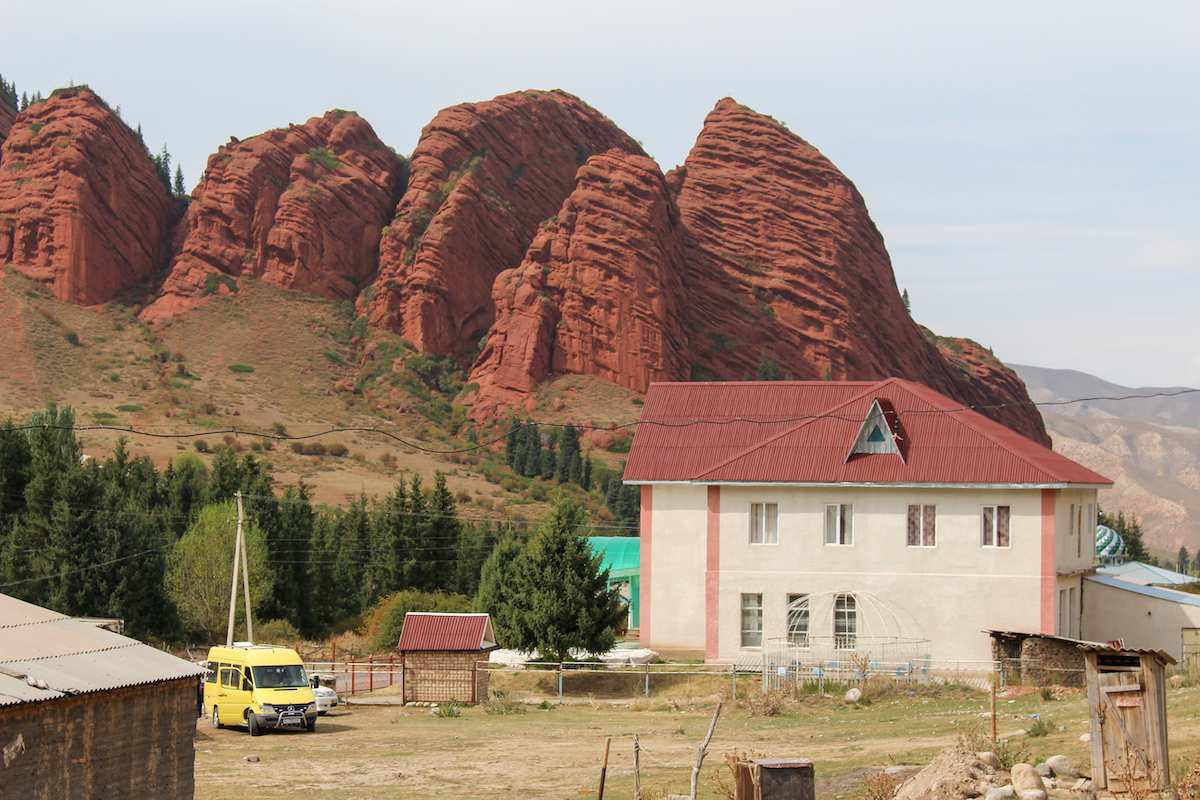 red-sandstone-formations-behind-simple-buildings-at-jeti-oguz-in-kyrgyzstan