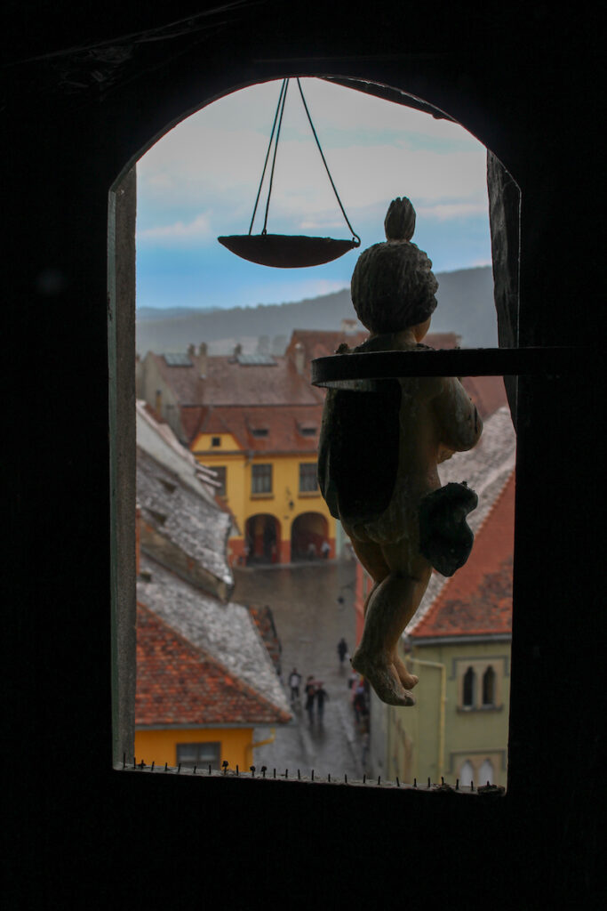 view-from-top-of-tower-in-sighisoara-with-silhouette-of-clock-figurines-in-the-foreground