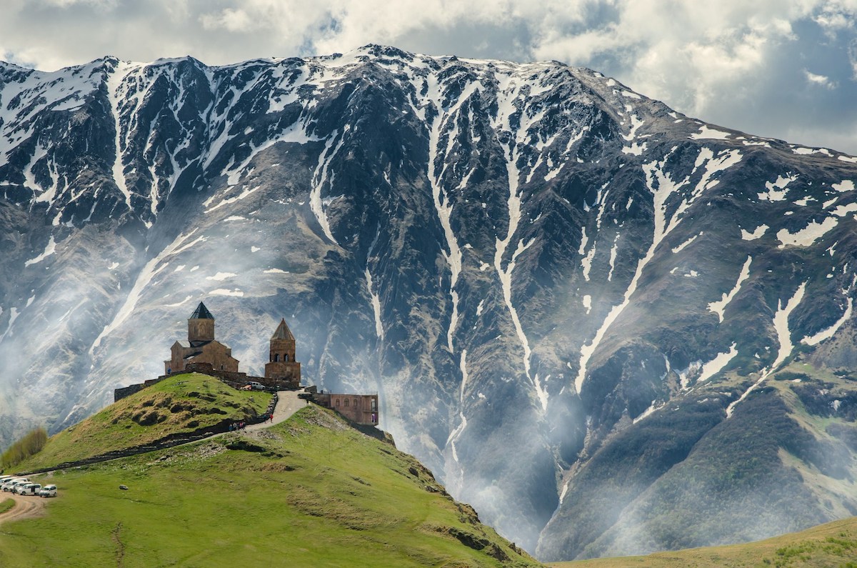 Holy Trinity Church kazbegi georgia with imposing snowy mountain behind