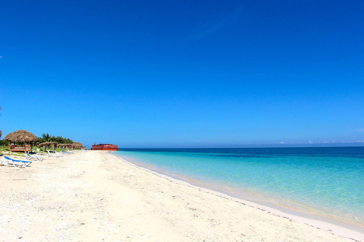 pristine white sand beach with turquoise sea and blue sky in cayo levisa cuba