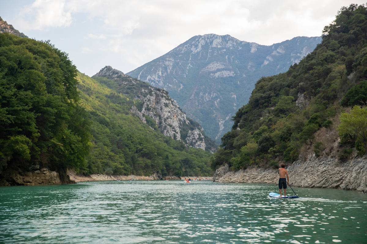 man stand up paddleboarding in the verdon gorge in provence