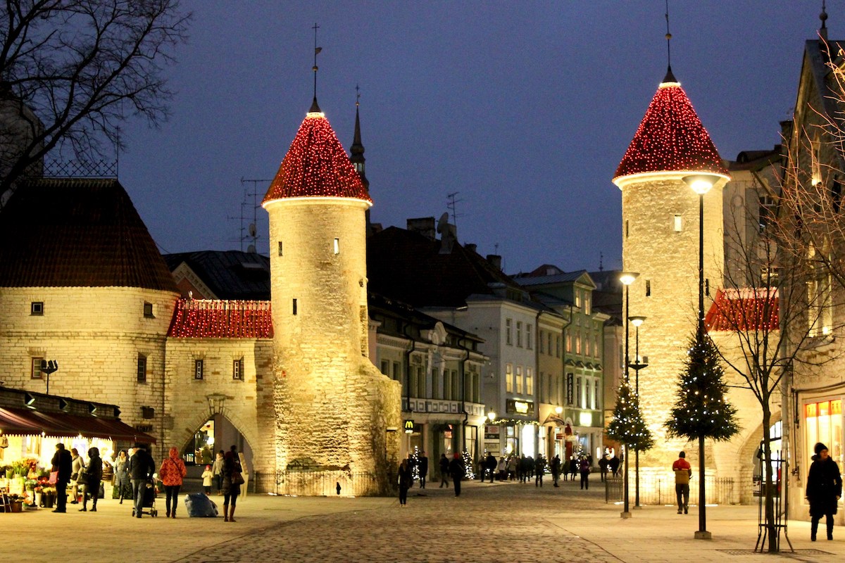 tallinn's medieval towers with red roofs lit up at night