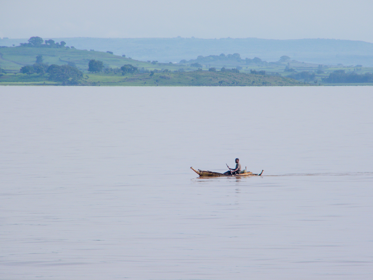 man paddling a traditional wooden canoe on lake tana in ethiopia