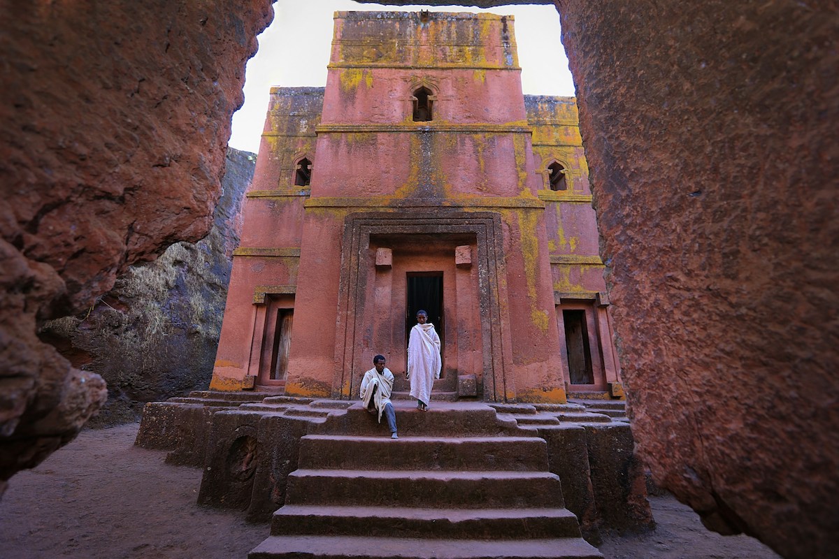 priests in white outside st george church Bete Giyorgis in lalibela