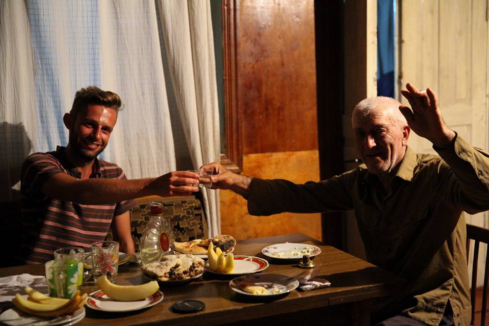 alex tiffany toasting with a georgian man while enjoying a traditional georgian meal and hospitality