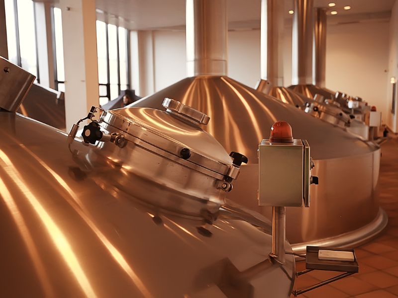 large copper fermentors inside a brewery