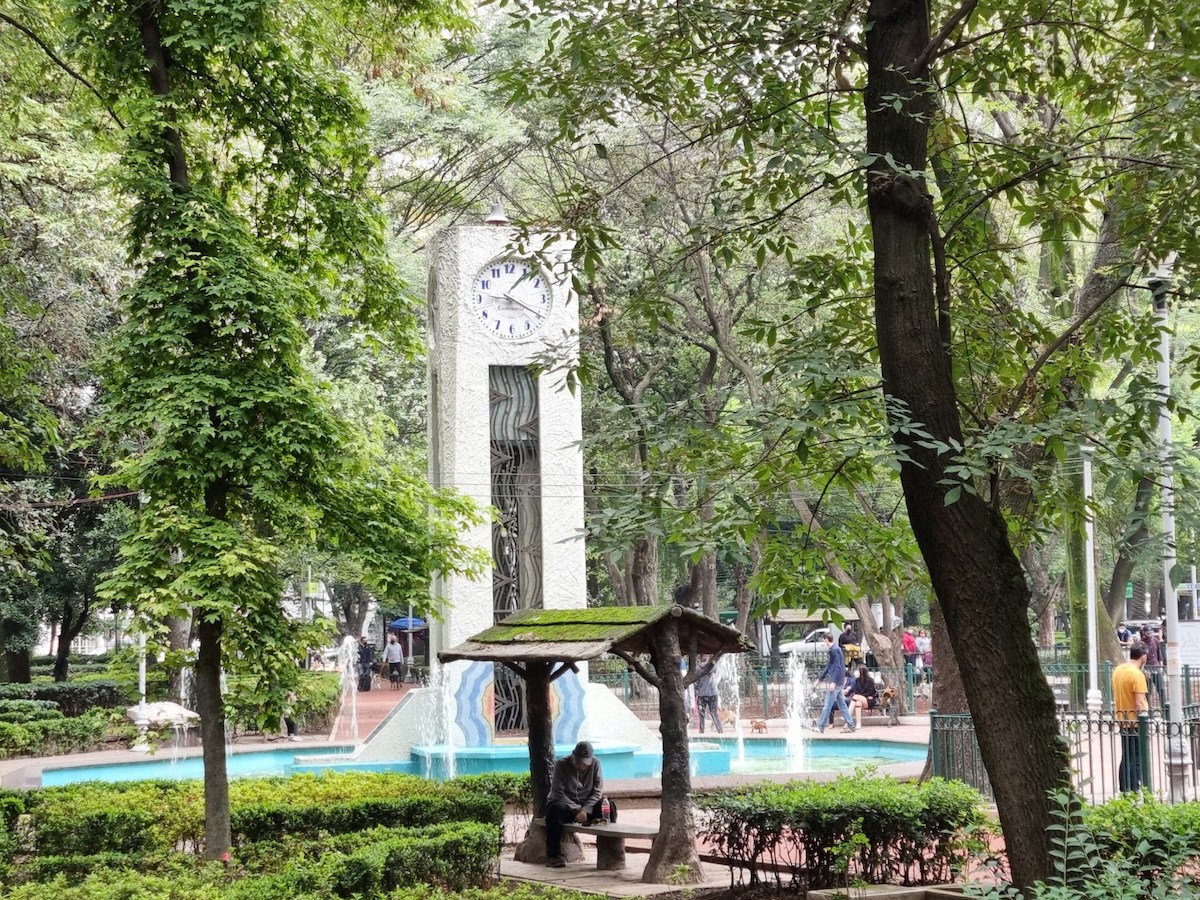 Green park with fountain and clocktower in Hipodromo Mexico City