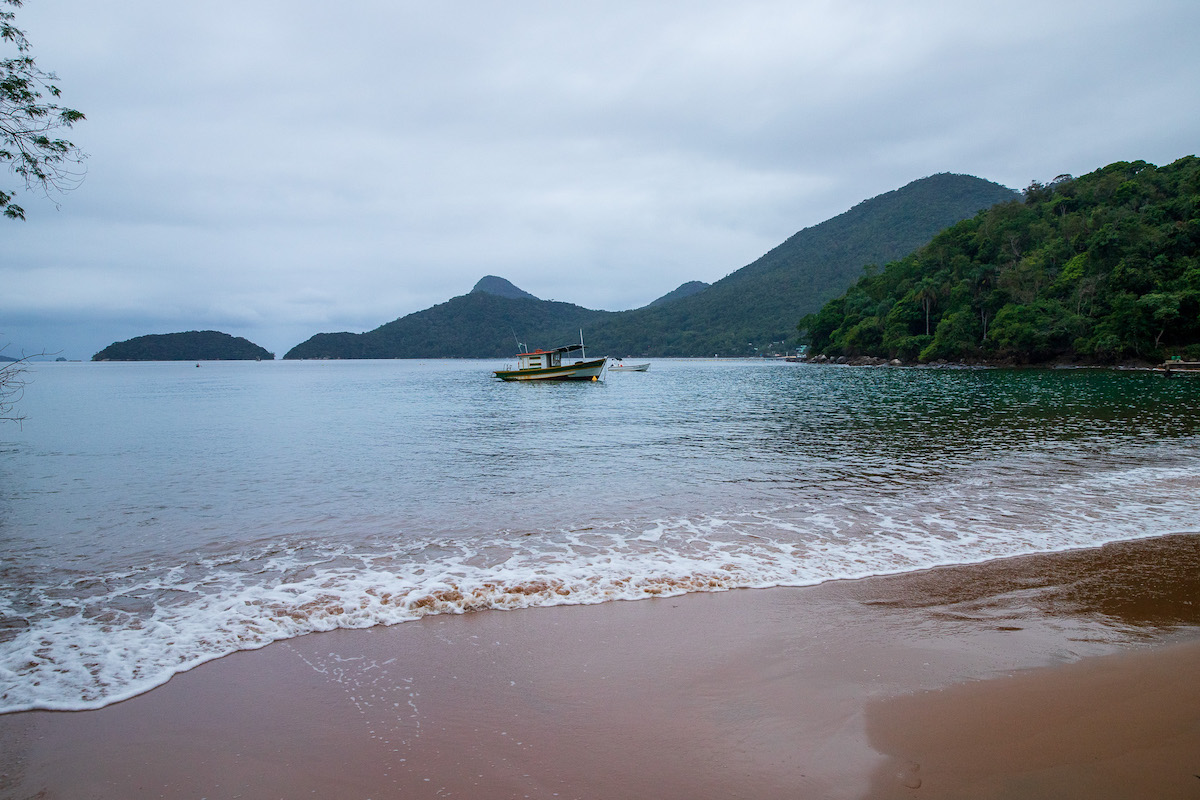 peaceful secluded beach on ilha grande with a boat offshore