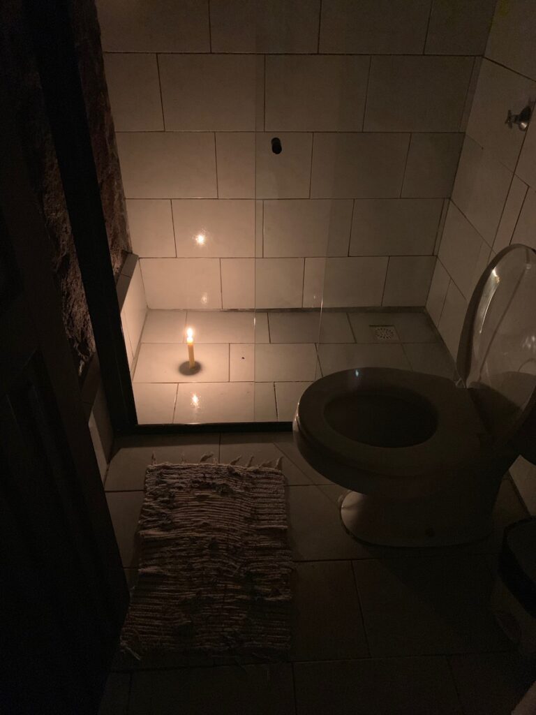 candle illuminating a bathroom at pousada lagamar hotel in ilha grande