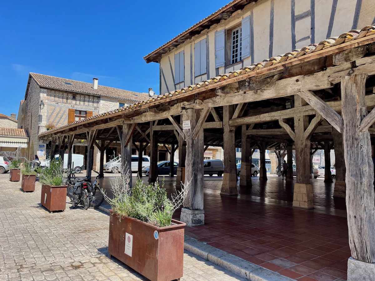Looking inside the covered market square with its old wooden beams and orange tiled floor in Villereal