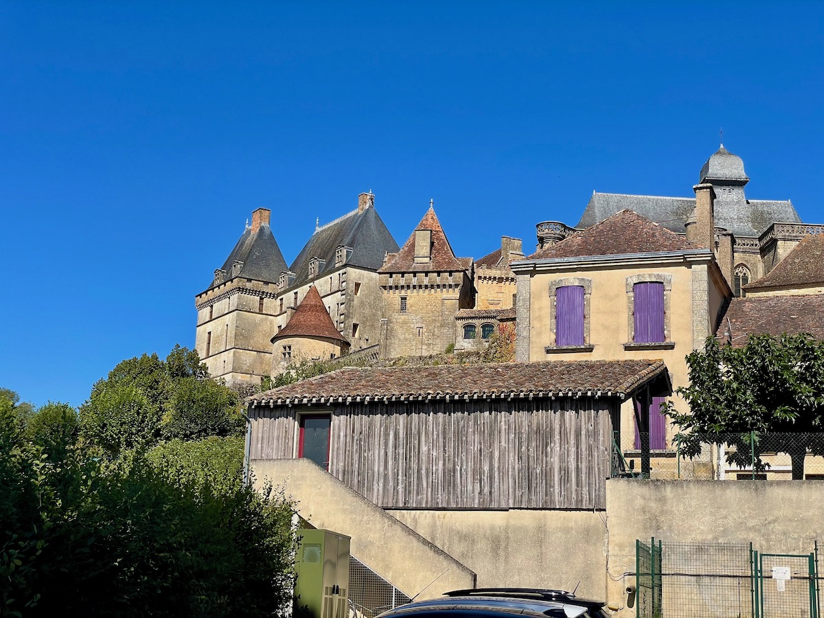 Chateau de Biron castle and a few old houses with wooden shutters