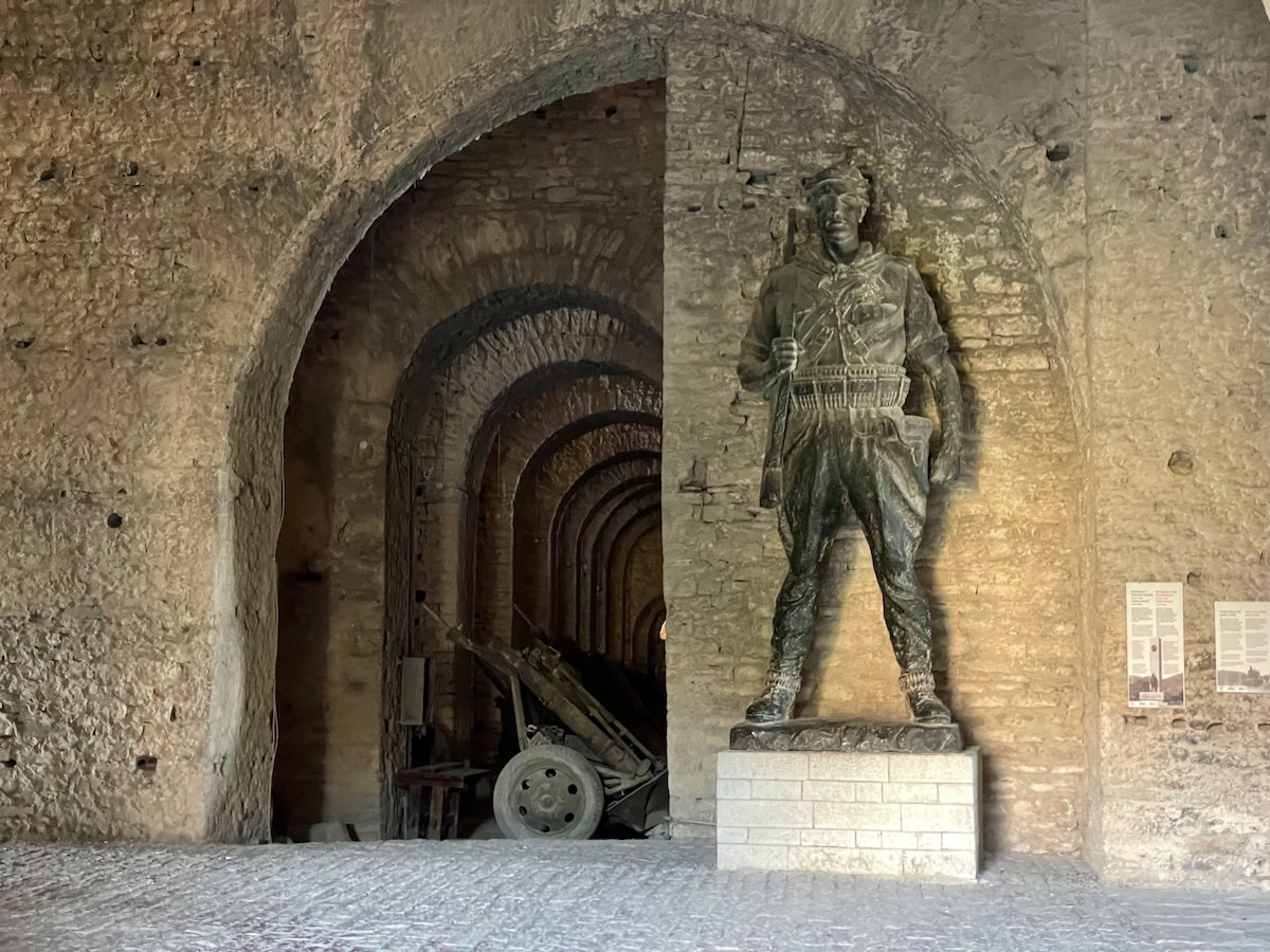 Ancient soldier statue in a historic fortress tunnel inside Gjirokaster castle, exploring military history and architecture.