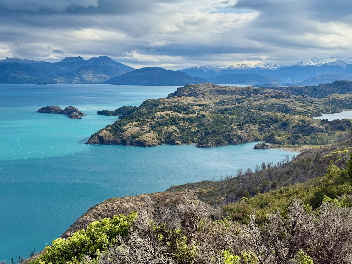 Panoramic view of turquoise Lago General Carrera, rocky islands and distant mountains in Chilean Patagonia